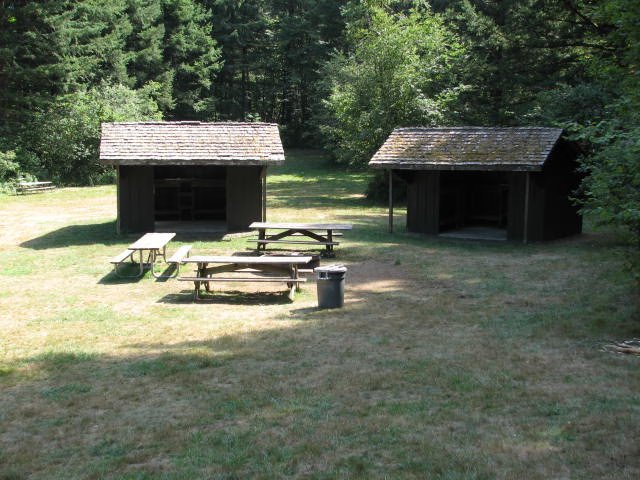 Sleeping shelters and picnic tables in a clearing
